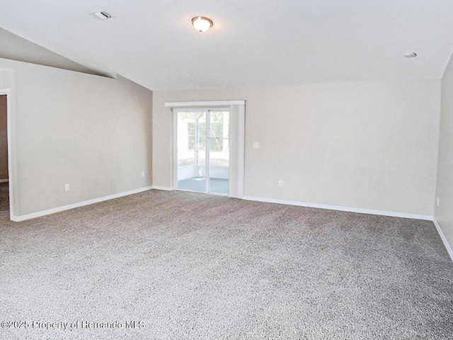 spare room with lofted ceiling, baseboards, and visible vents