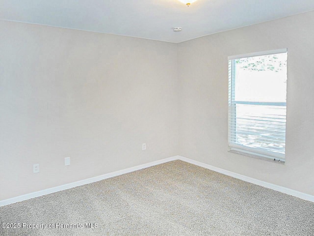 empty room featuring a wealth of natural light and baseboards