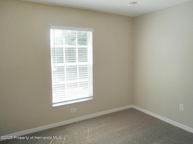 empty room with carpet and baseboards