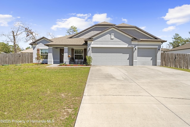 view of front of property featuring a garage, concrete driveway, a front yard, and fence