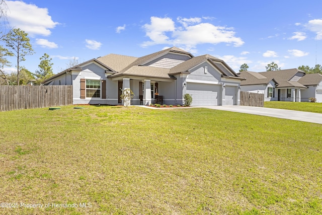 view of front of property with a front yard, fence, an attached garage, stucco siding, and concrete driveway