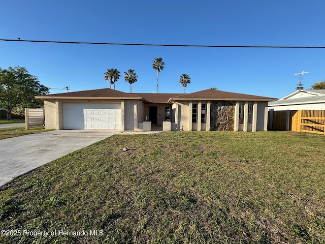 ranch-style home with stucco siding, a front lawn, driveway, fence, and an attached garage