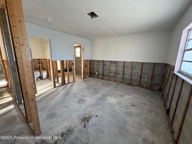 unfurnished room featuring concrete floors and a textured ceiling