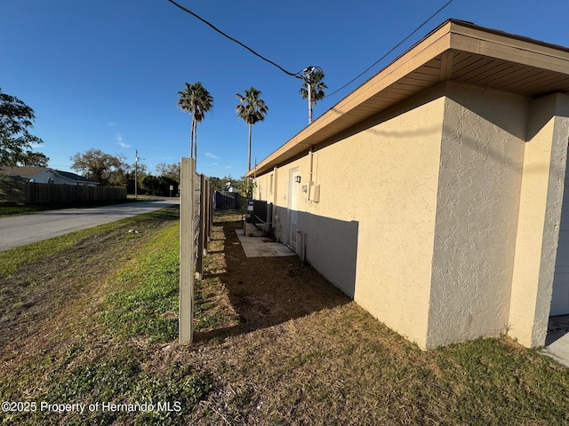 view of property exterior with fence and stucco siding