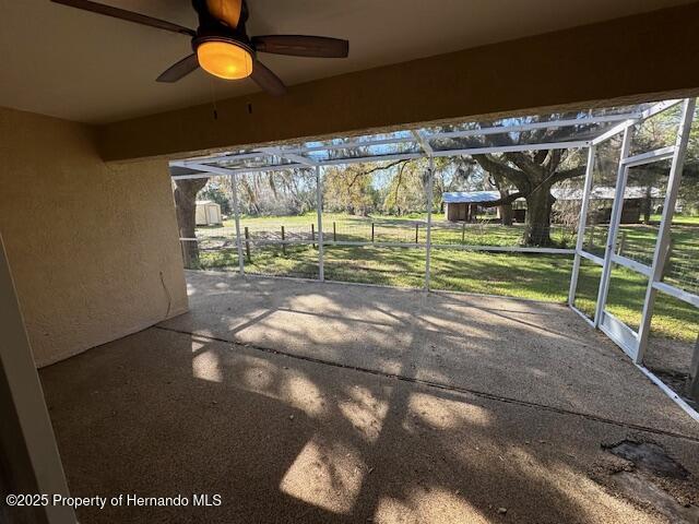 view of patio featuring a lanai and ceiling fan