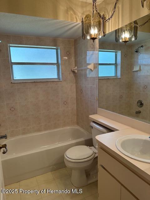 bathroom with tile patterned floors, vanity, toilet, and  shower combination