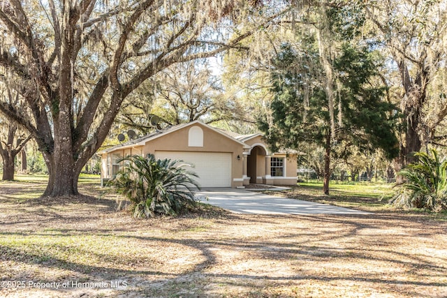 view of front of property with concrete driveway, a garage, and stucco siding