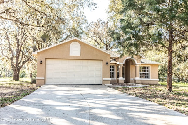 single story home with stucco siding, a garage, and driveway