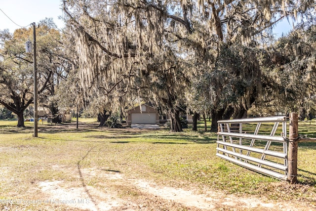 view of yard featuring an outbuilding, a garage, and fence