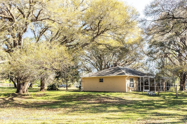 view of yard featuring glass enclosure and fence