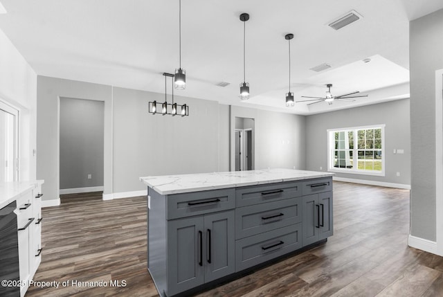 kitchen featuring visible vents, gray cabinets, dark wood-type flooring, and baseboards