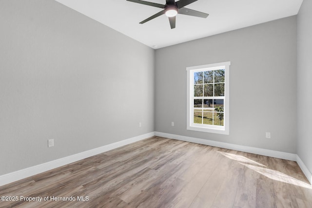 spare room with a ceiling fan, wood finished floors, and baseboards