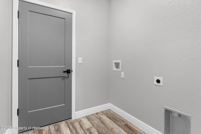 clothes washing area with electric dryer hookup, wood finished floors, baseboards, hookup for a washing machine, and laundry area