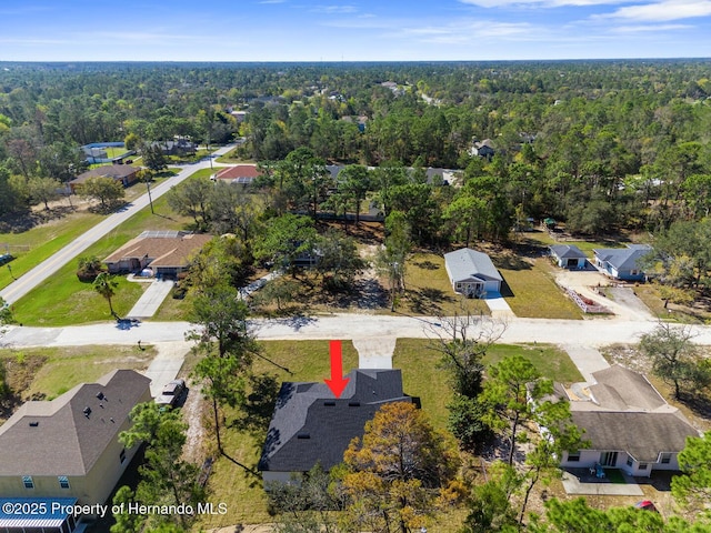 bird's eye view with a wooded view