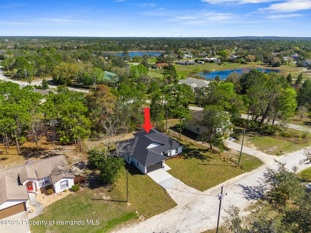 aerial view with a water view and a wooded view