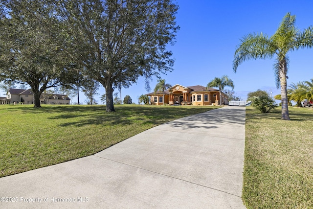 view of front of home with concrete driveway and a front lawn