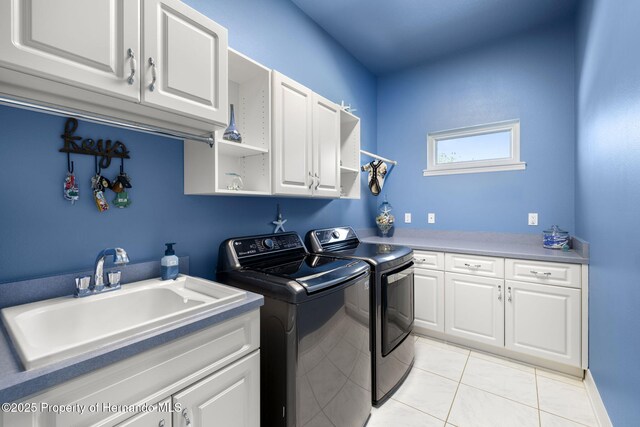 laundry area featuring separate washer and dryer, light tile patterned floors, cabinet space, and a sink