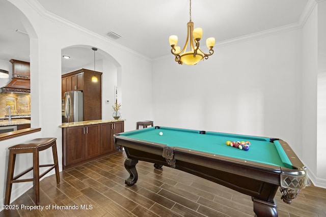 game room featuring arched walkways, visible vents, crown molding, and wood finish floors