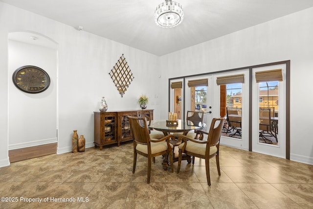dining space with french doors and baseboards