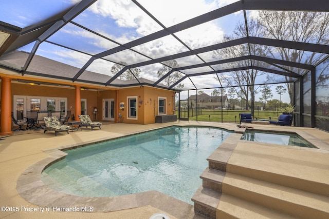 pool with glass enclosure, a patio area, and french doors