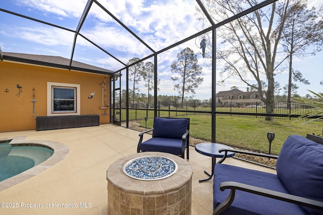view of patio / terrace with a lanai, fence, and an outdoor fire pit