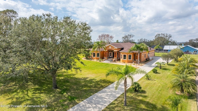 exterior space with a front lawn, an attached garage, driveway, and stucco siding