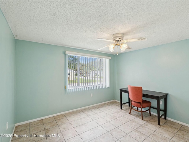 home office with tile patterned floors, a ceiling fan, baseboards, and a textured ceiling