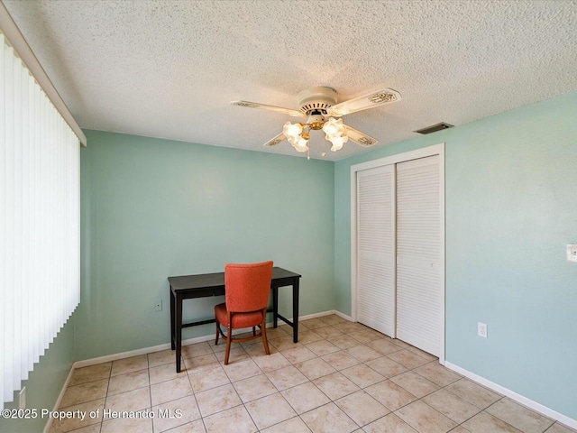 tiled home office with baseboards, a ceiling fan, visible vents, and a textured ceiling