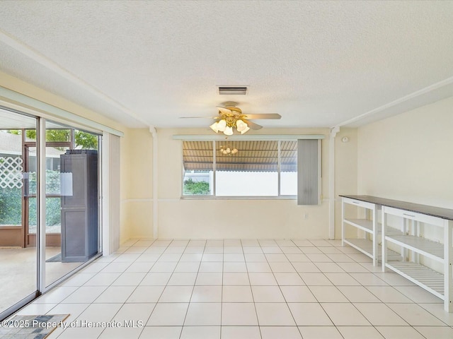 unfurnished room with visible vents, plenty of natural light, and light tile patterned flooring