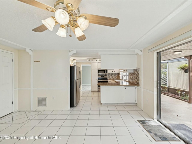 kitchen featuring light tile patterned floors, stainless steel appliances, visible vents, and white cabinets