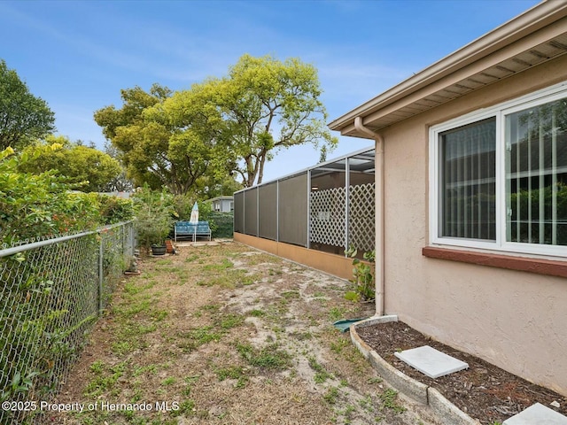 view of yard featuring a lanai and fence