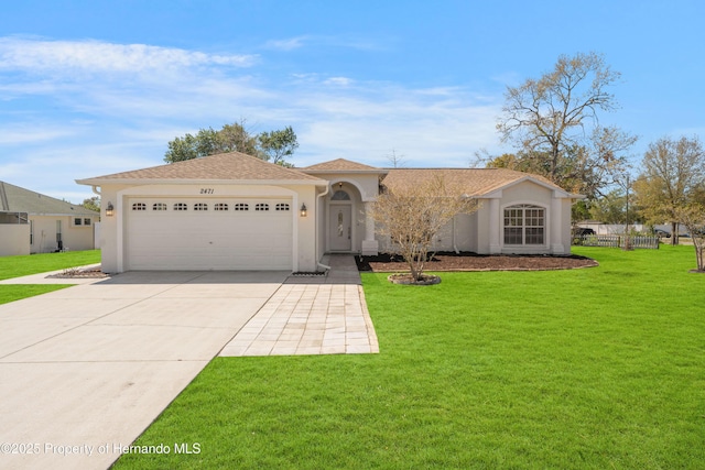 view of front of property with a front yard, fence, stucco siding, concrete driveway, and a garage