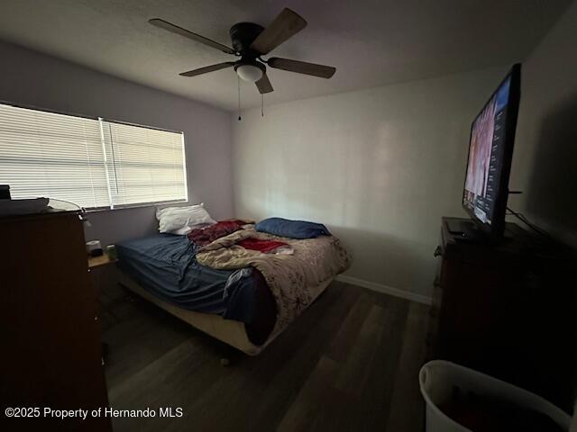 bedroom featuring wood finished floors, baseboards, and ceiling fan