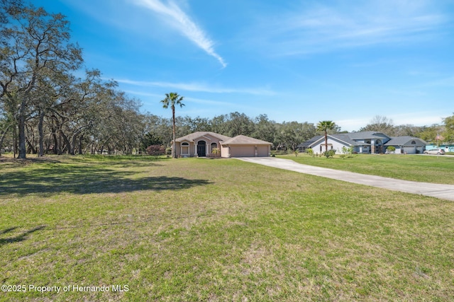 view of front of property featuring a garage, a front lawn, and driveway