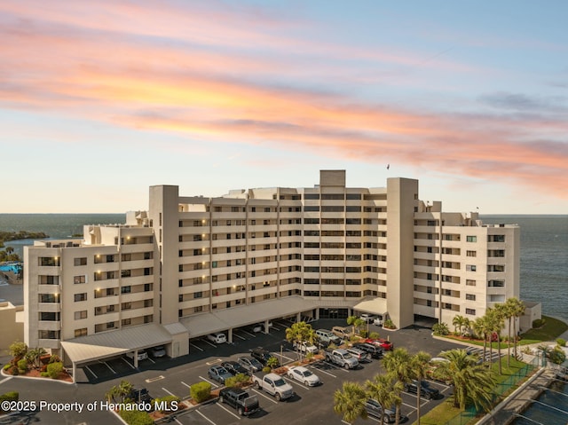 view of property featuring a water view and uncovered parking