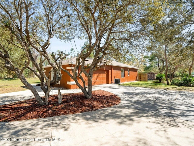 view of front of home featuring fence, a garage, driveway, and stucco siding