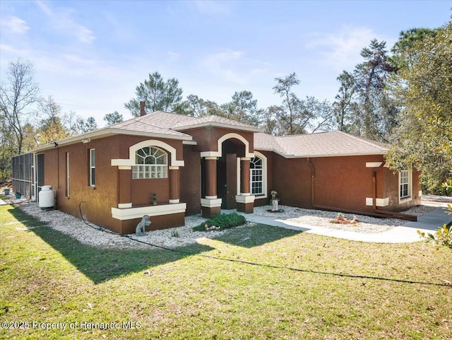 mediterranean / spanish house with a front yard and stucco siding