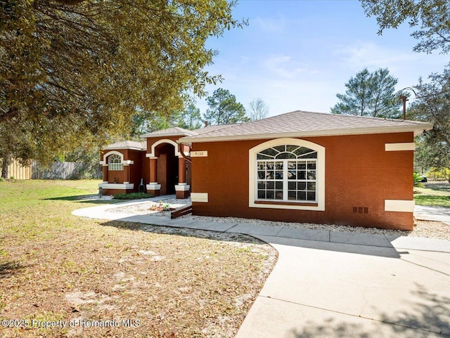 view of front of property featuring crawl space, stucco siding, a front yard, and fence