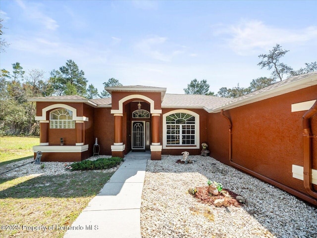 view of front of home featuring stucco siding and a front yard