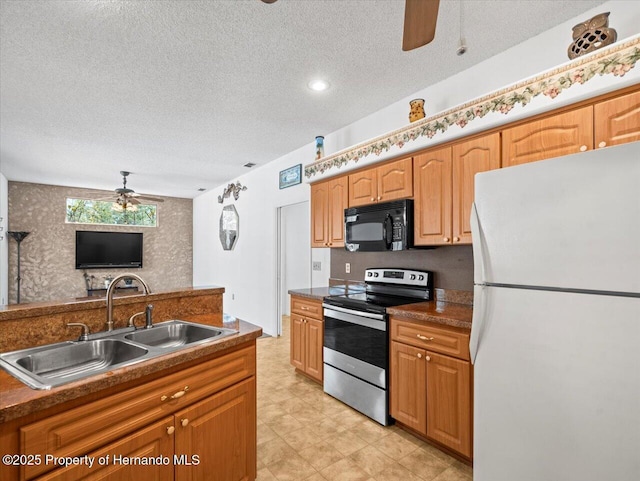 kitchen featuring a ceiling fan, freestanding refrigerator, a sink, stainless steel range with electric cooktop, and black microwave