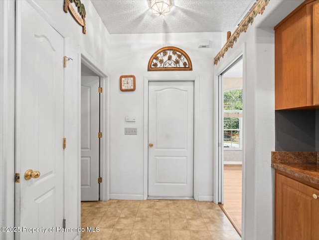 entrance foyer with baseboards and a textured ceiling