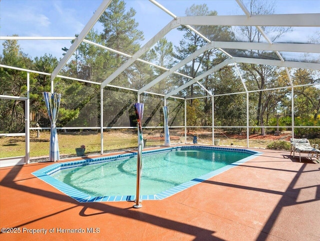 outdoor pool with glass enclosure and a patio