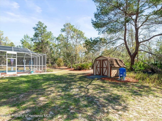 view of yard with glass enclosure, an outdoor structure, a swimming pool, and a shed