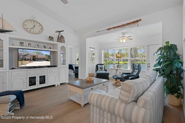 living room with vaulted ceiling, a ceiling fan, and light wood finished floors