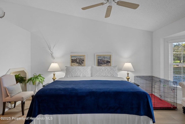 bedroom with a textured ceiling, a ceiling fan, and wood finished floors