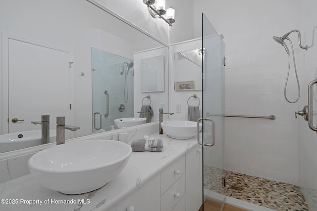 full bath featuring a sink, double vanity, and a shower stall