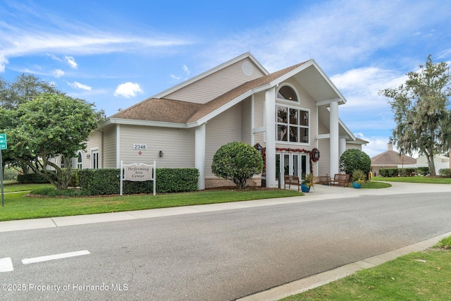 view of front of property with a front lawn, french doors, and roof with shingles