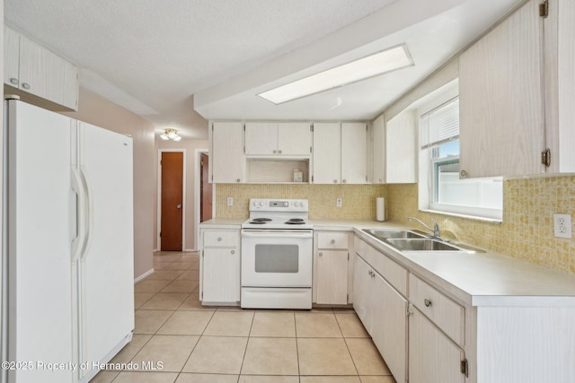 kitchen featuring white appliances, light tile patterned floors, a sink, light countertops, and tasteful backsplash