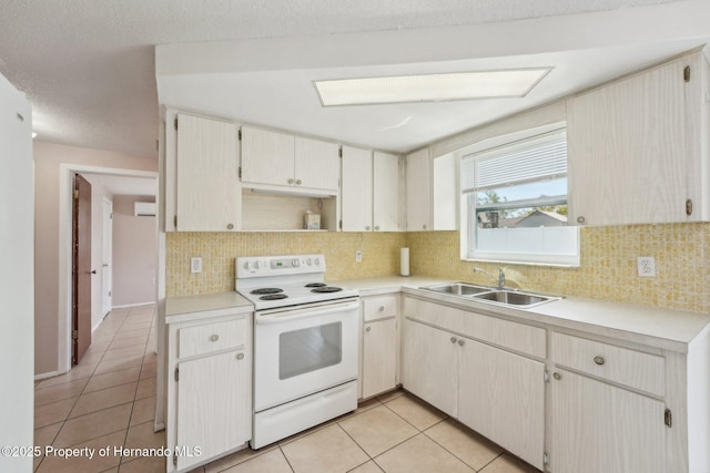 kitchen with a sink, backsplash, light tile patterned floors, and white range with electric cooktop