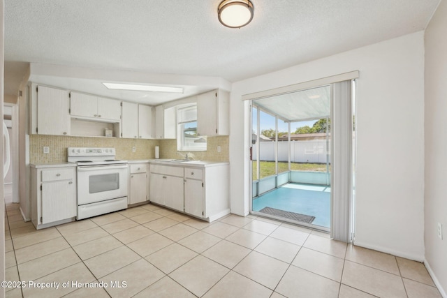 kitchen with decorative backsplash, light countertops, white electric range, and white cabinetry